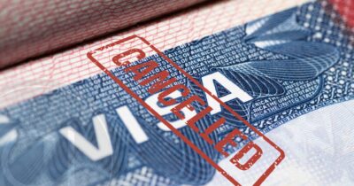 U.S. visa with red "CANCELLED" stamp, symbolizing travel bans and immigration restrictions