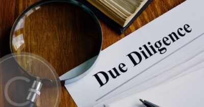 Magnifying glass over due diligence document, representing compliance and background checks